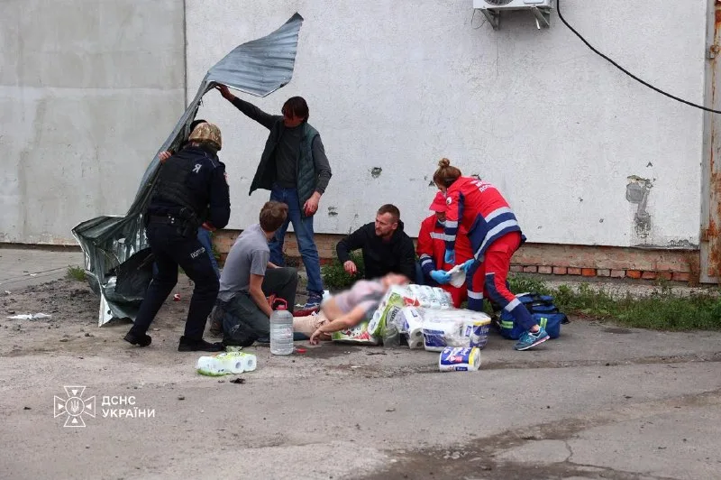 Медики оказывают помощь пострадавшему возле повреждённого здания.