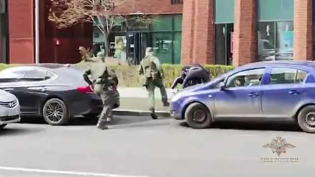 Кадр опубликованного видео задержания — сотрудники рядом с задержанным
